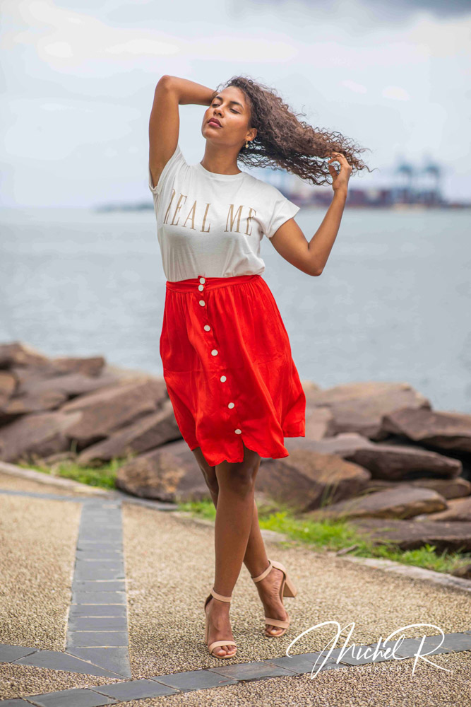 Portrait de mode au bord de l’eau, jupe rouge en mouvement