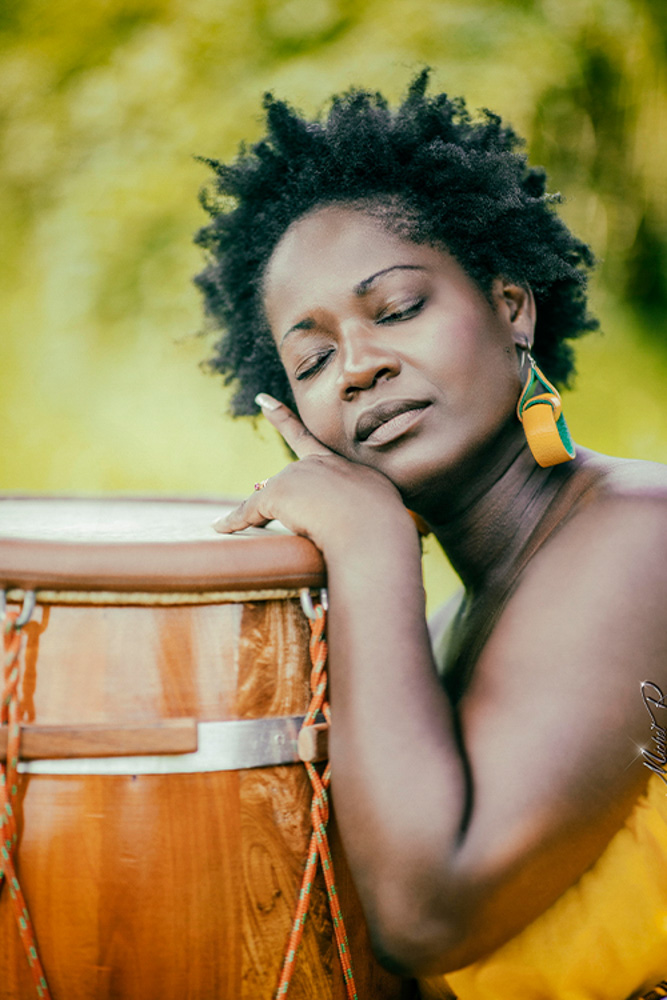 Portrait d’une femme posant auprès d’un tambour, photographiée par Michel R.